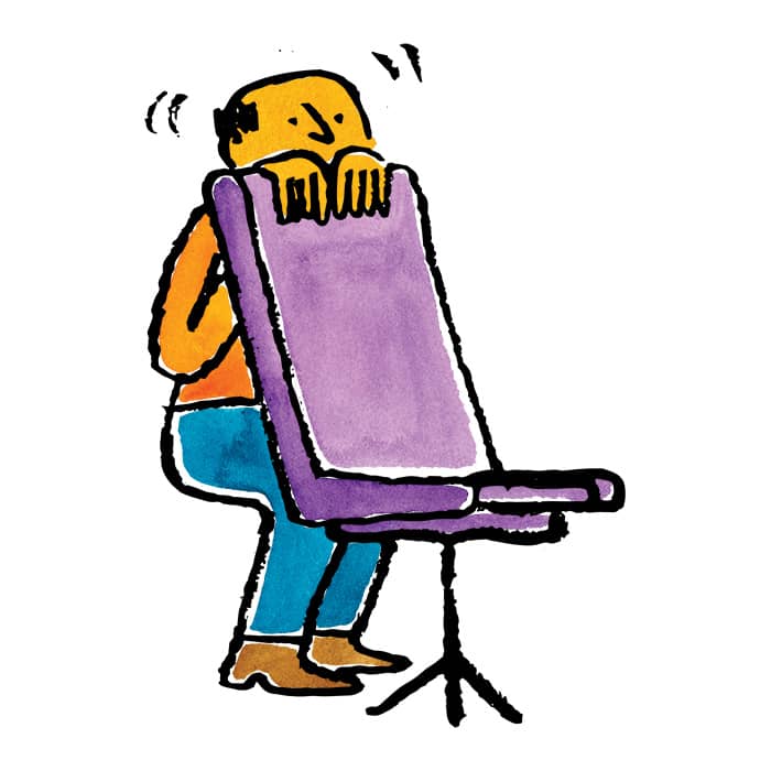 a man hiding behind a chair